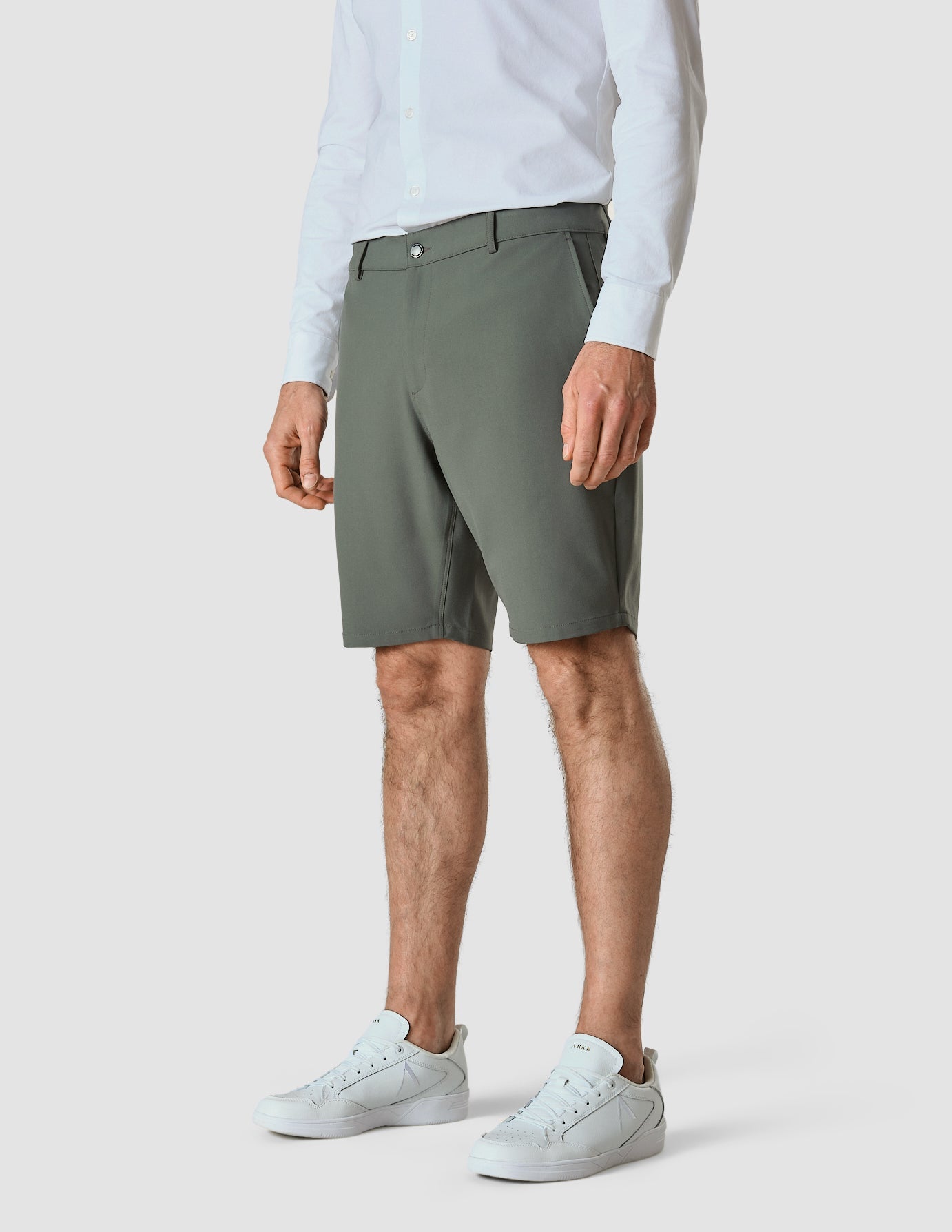 Model seen from the front wearing essential Shorts urban green shorts with a white shirt